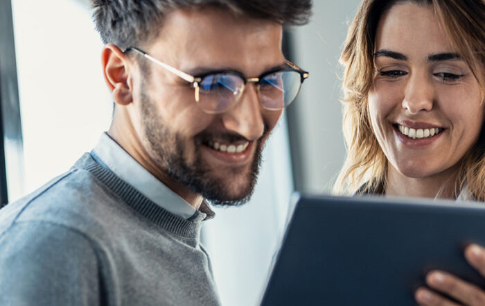 hombre y mujer en ambiente laboral mirando una tablet